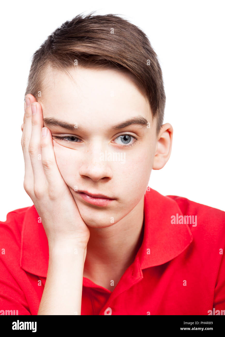 Portrait of bored teenager boy with his hand on chin isolated on white