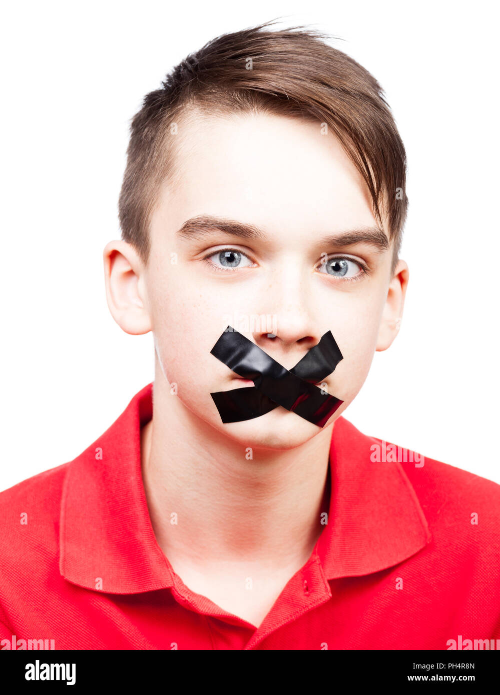Portrait of teenager boy with duct tape on his mouth - silenced child concept Stock Photo