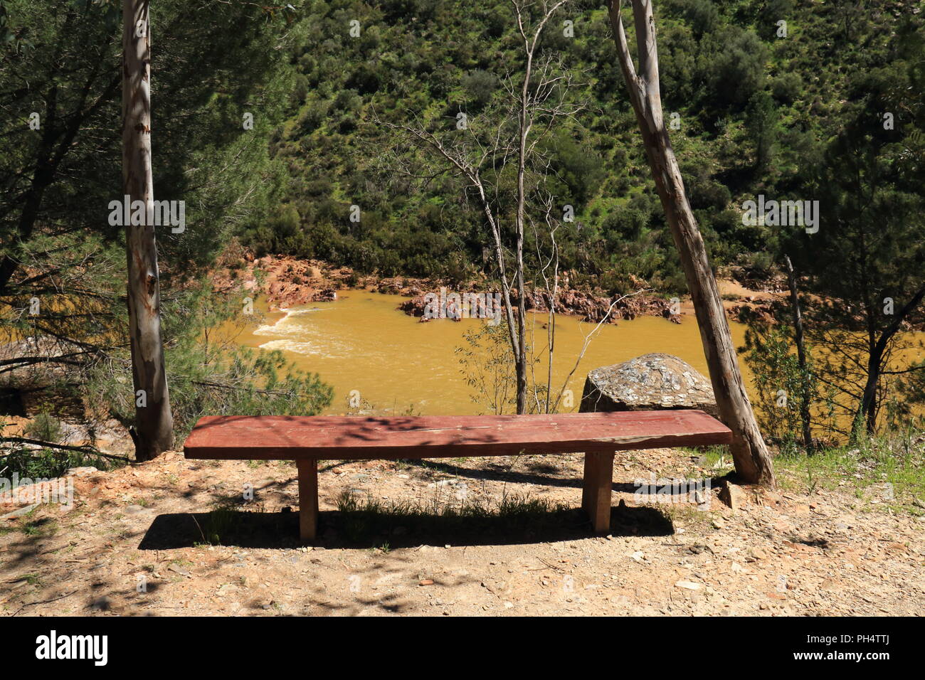 Wooden bench by the river Odiel, on the so-called route of the mills, great for hiking in the province of Huelva, Spain Stock Photo