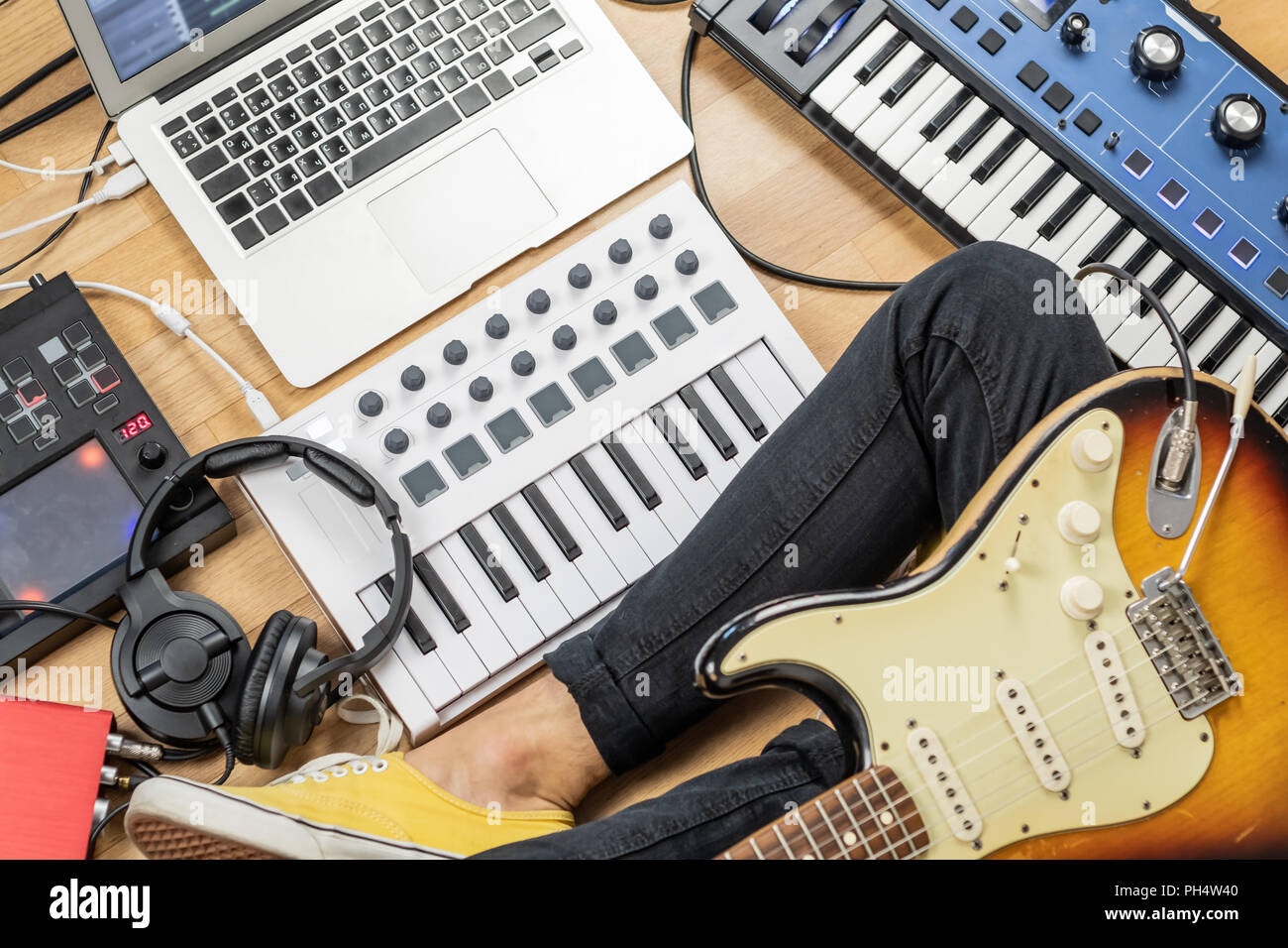 Male guitarist with electric guitar at modern home studio or rehearsal