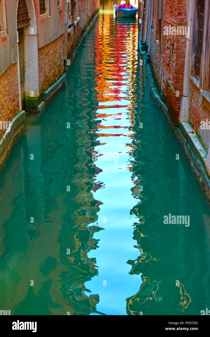 Houses and sky reflect in the water of canal, Veinice Stock Photo