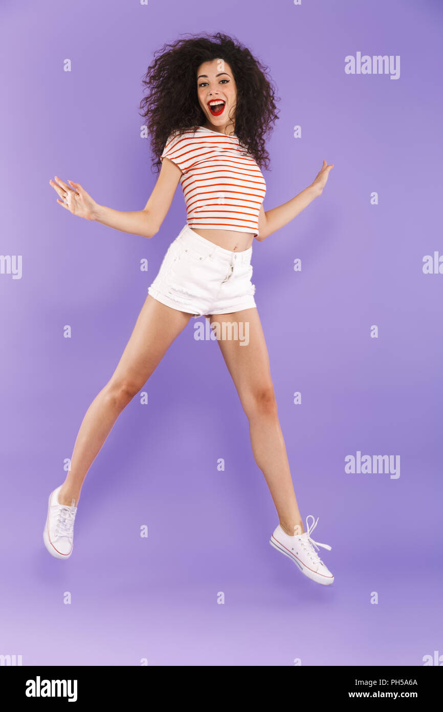 Full length portrait of a pretty young casual woman jumping isolated ...