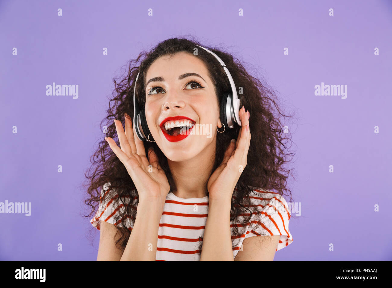 Portrait of a happy young casual woman listening to music with ...