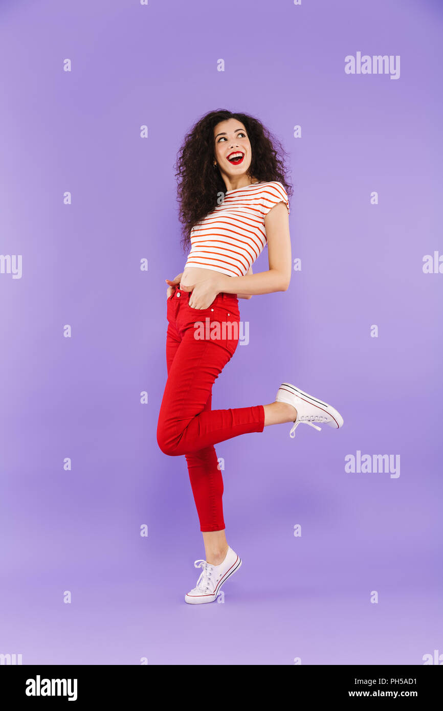 Full length portrait of a happy young casual woman posing while ...