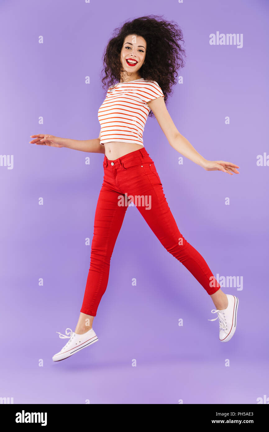 Full length portrait of a pretty young casual woman jumping isolated ...