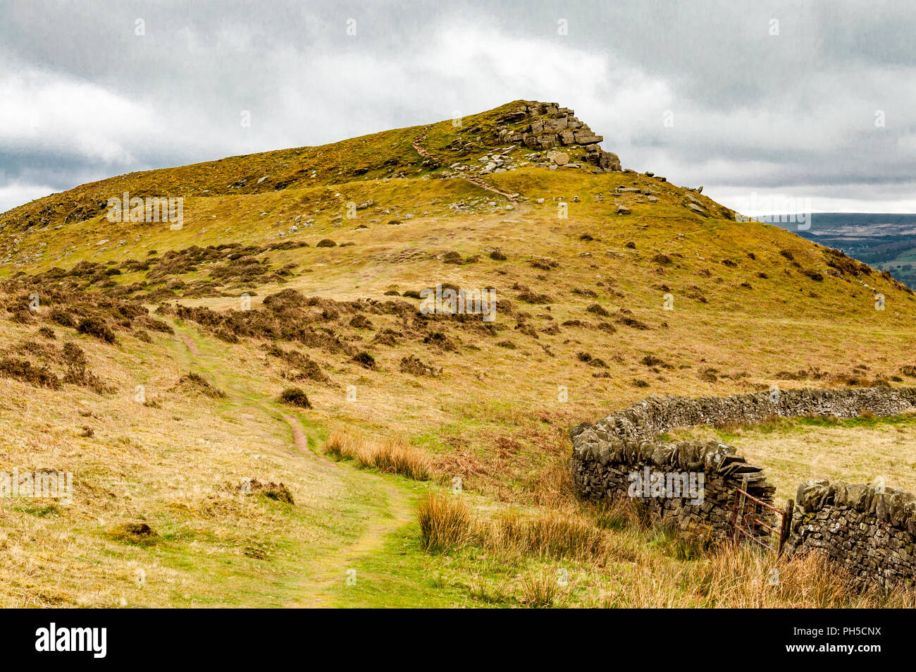 A grass and stone hill and a dry stone wall and gate in Brecon Beacons National Park, Powys, Wales Stock Photo