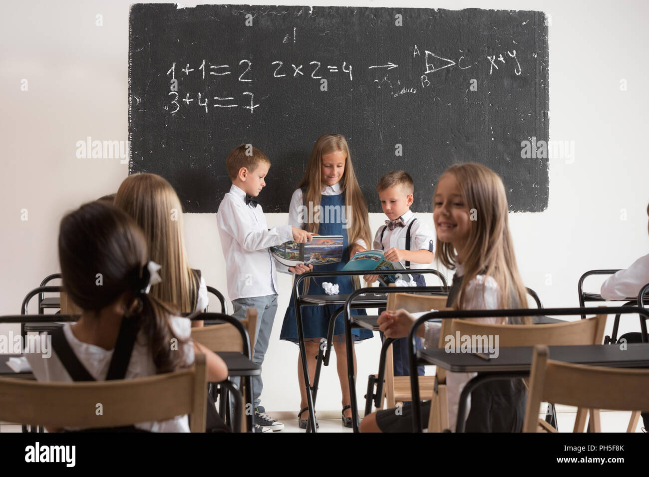 School Children In Classroom At Lesson The Little Boys And Girls