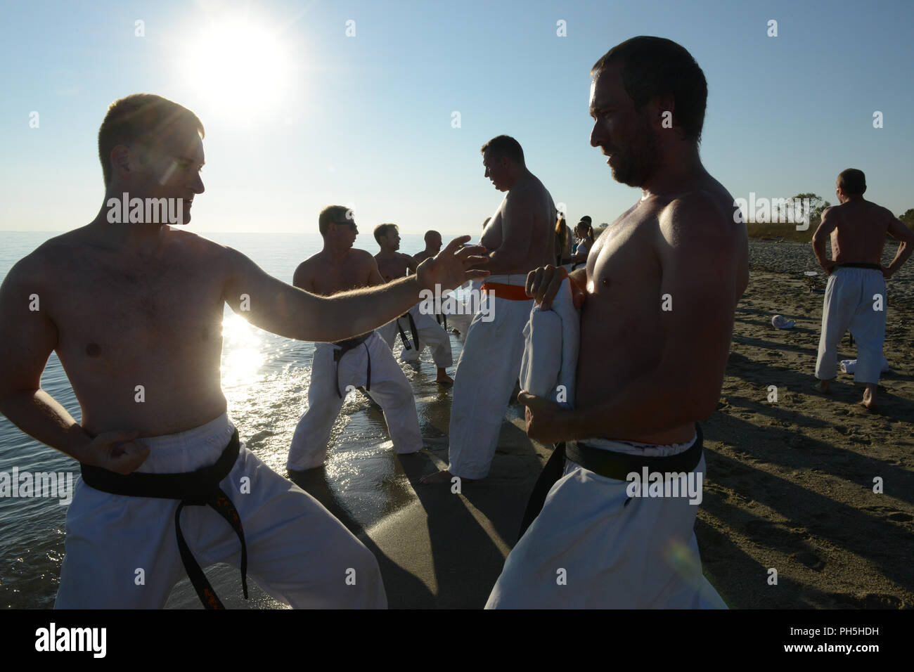 Karatekas seen at a training class at the beach of mediteranian sea in Greece Stock Photo