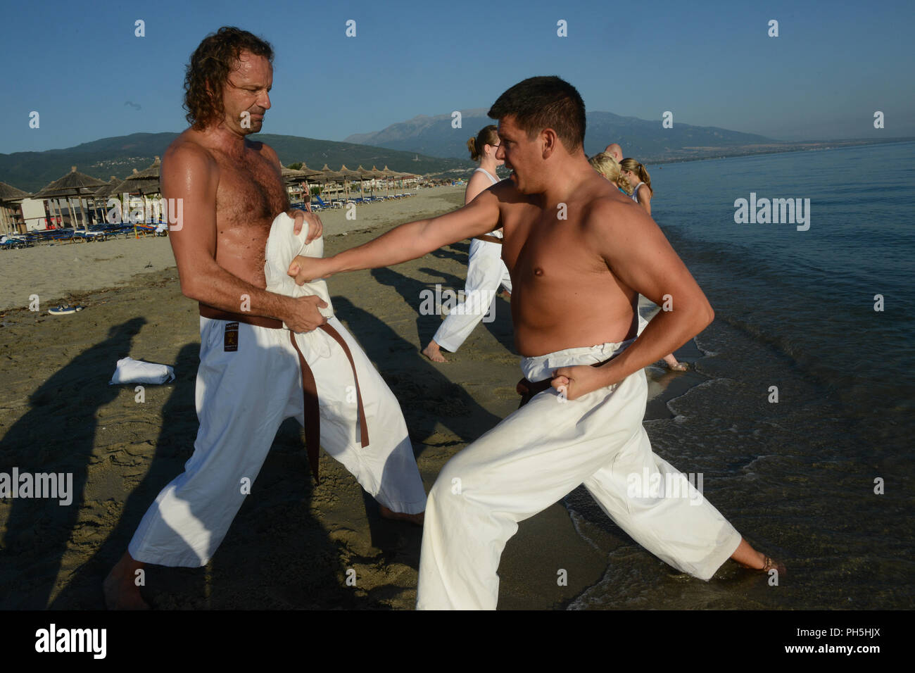 Karatekas seen at a training class at the beach of mediteranian sea in Greece Stock Photo