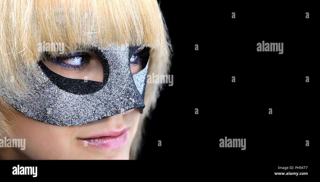 closeup portrait of young  woman with masquerade mask, isolated on black  background, banner format Stock Photo