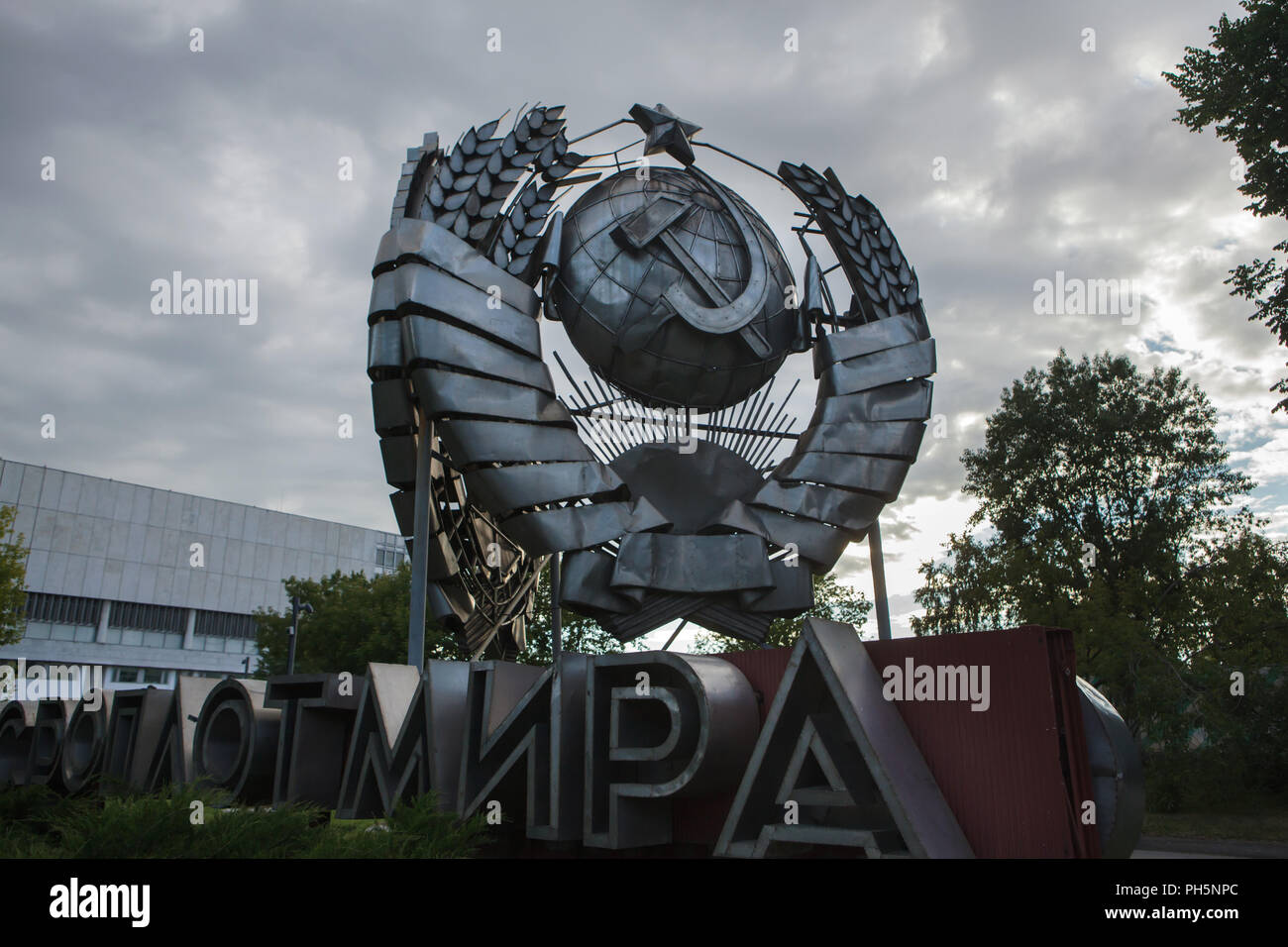 State Emblem of the Soviet Union designed by Soviet sculptor Stepan Schekotikhin on display in the Muzeon Fallen Monument Park in Moscow, Russia. The huge stainless state emblem was previously instated in Leninsky Avenue in Moscow. The inscription in Russian under the state emblem means: USSR is the Stronghold of the Peace. Stock Photo