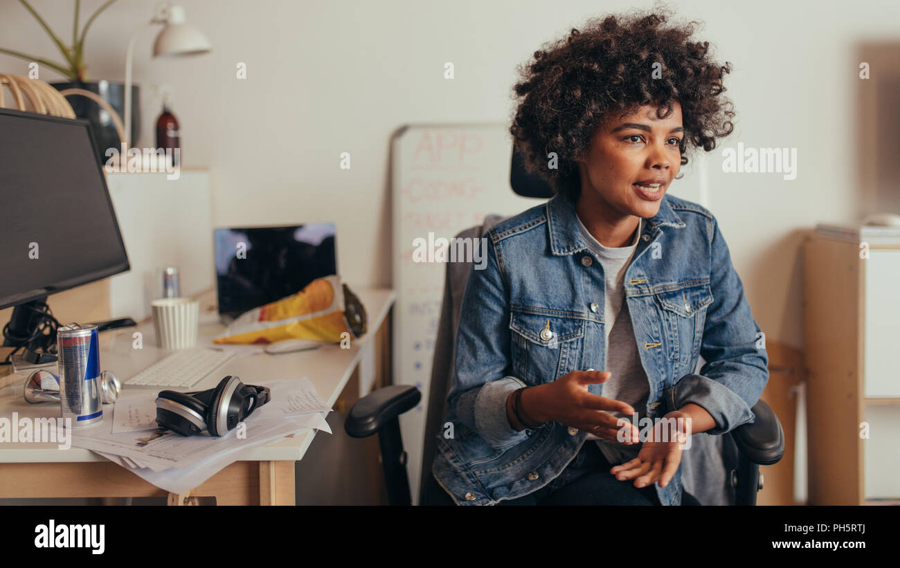 Female startup owner sharing few business ideas with team. businesswoman explaining new software development project to her team. Stock Photo