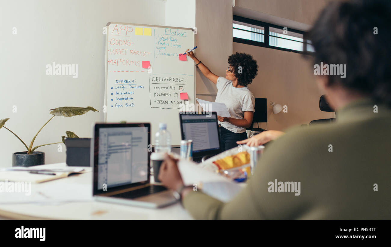 Team leader discussing and brainstorming new approaches and ideas with colleagues over new project. Business presentation at software development comp Stock Photo
