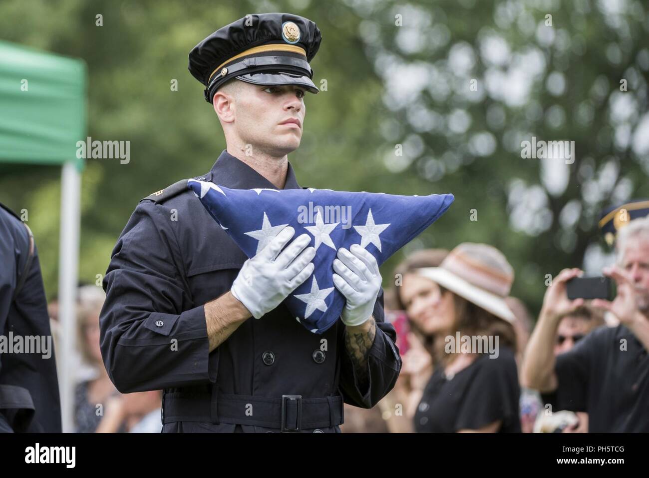 A soldier from the U.S. Army Honor Guard carries a U.S. flag during the Full Honors Group Funeral Service for U.S. Army Air Forces Airmen missing from World War II in Section 60 of Arlington National Cemetery, Arlington, Virginia, June 27, 2018. Laid to rest were Airmen Tech. Sgt. John Brady; Tech. Sgt. Allen Candler, Jr.; 1st Lt. John Liekhus; Staff Sgt. Robert Shoemaker; and Staff Sgt. Bobby Younger.    All five Airmen were members of the 323rd Bombardment Squadron, 91st Bombardment Group (Heavy), Eighth Air Force, during World War II when their nine-man aircrew was on a mission to Merseburg Stock Photo