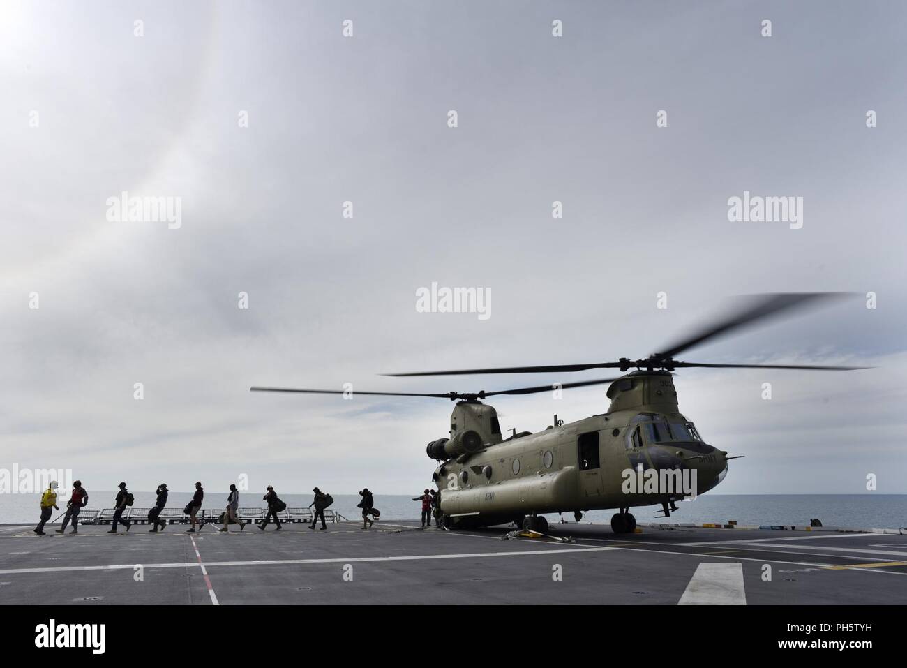 Role-players disembark from a CH-47 helicopter onto the HMAS Canberra ...