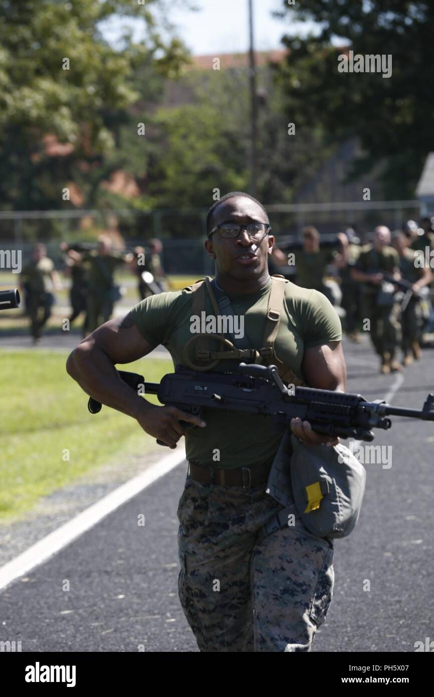 Sgt. Alphonso Ray, an assistant section leader with Chemical Biological Radiological and Nuclear Alpha Platoon, Chemical Biological Incident Response Force, carries an M240B machine gun aboard Naval Support Facility Indian Head, Md., June 15, 2018. Marines and Sailors with CBIRF, performed physical training to increase confidence with M53 gas mask. Stock Photo