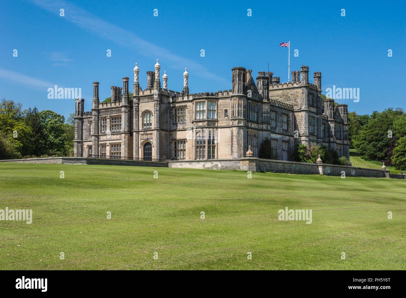 Edinburgh, Scotland, UK - June 14, 2012: Dalmany house, mansion and castle in Tudor revival style on green lawn, with Brittish flag and under blue sky Stock Photo