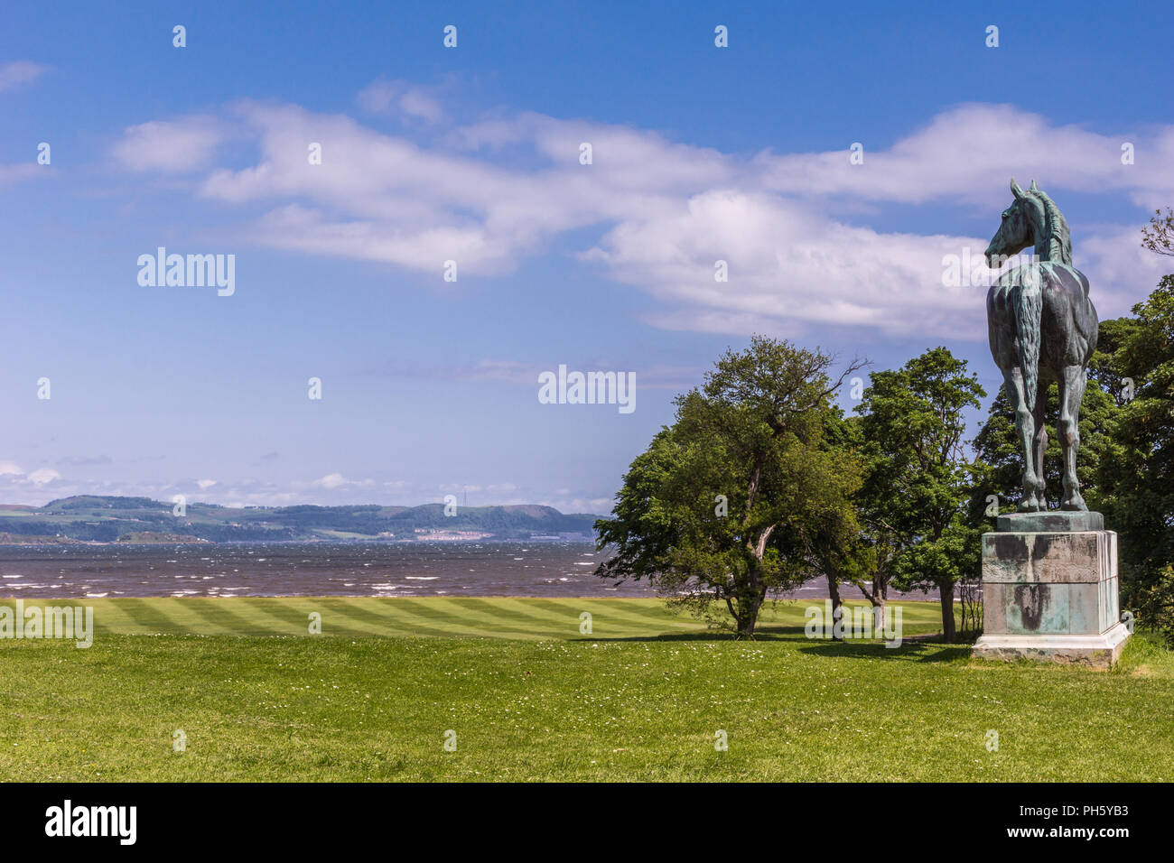 Edinburgh, Scotland, UK - June 14, 2012: Horse statue of King Tom looking at Firth of Forth on green lawn under blue sky at Dalmeny House. Stock Photo