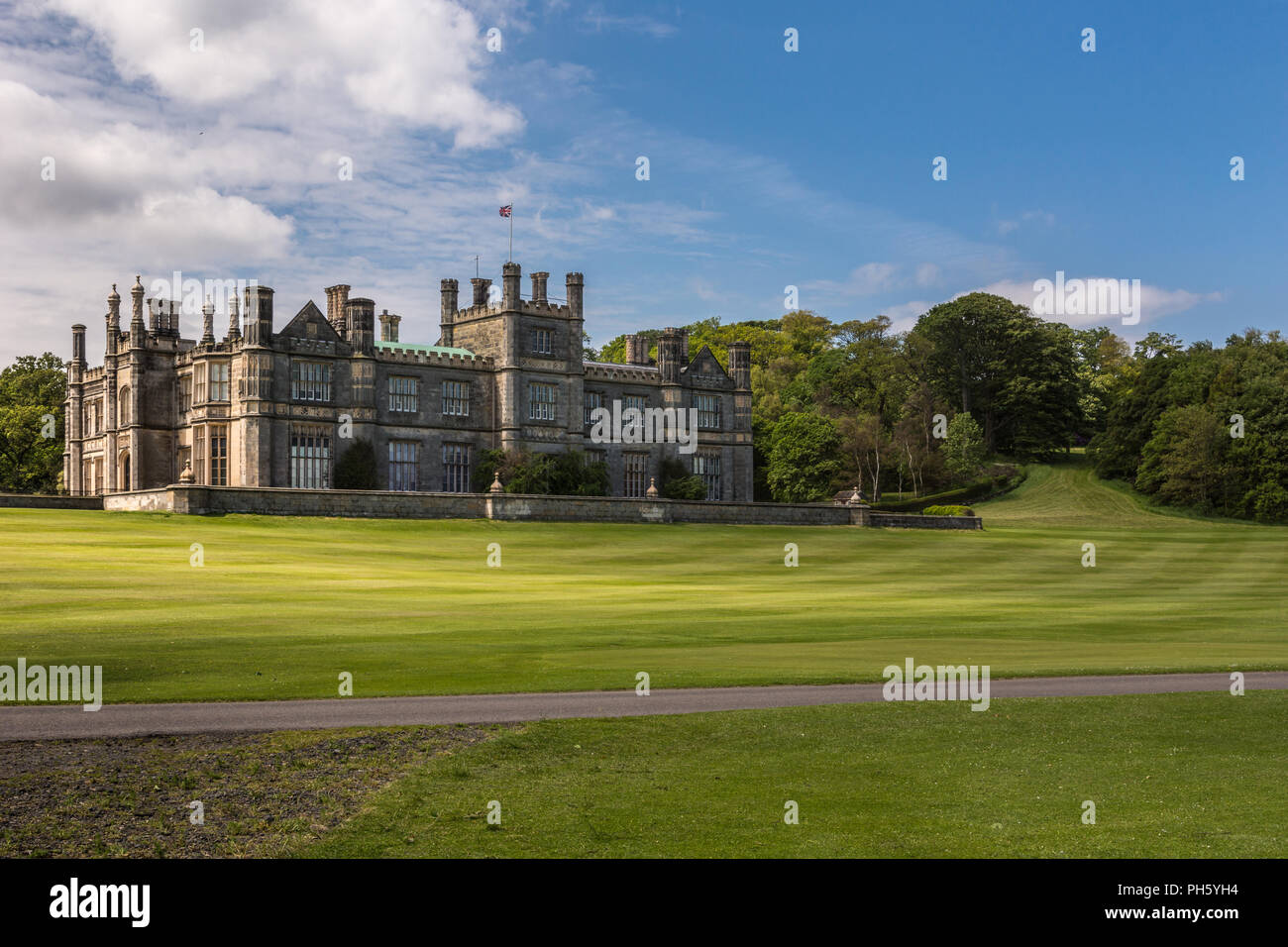 Edinburgh, Scotland, UK - June 14, 2012: Dalmany house, mansion and castle in Tudor revival style with the trees and its park in the back. Blue sky. Stock Photo