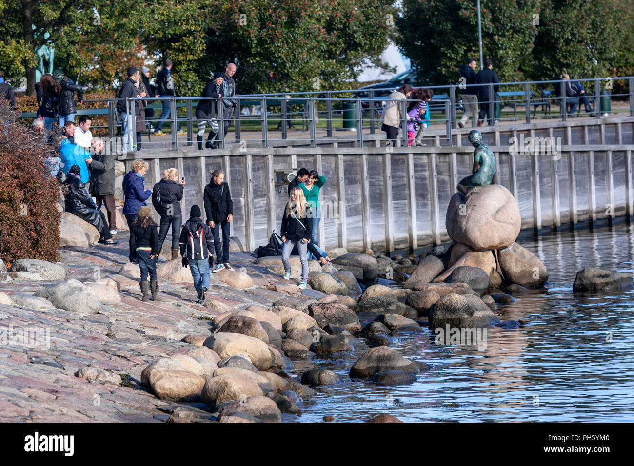Tourists taking pictures at the The Little Mermaid  bronze statue by Edvard Erikseni the waterside at the Langelinie promenade in Copenhagen, Denmark Stock Photo