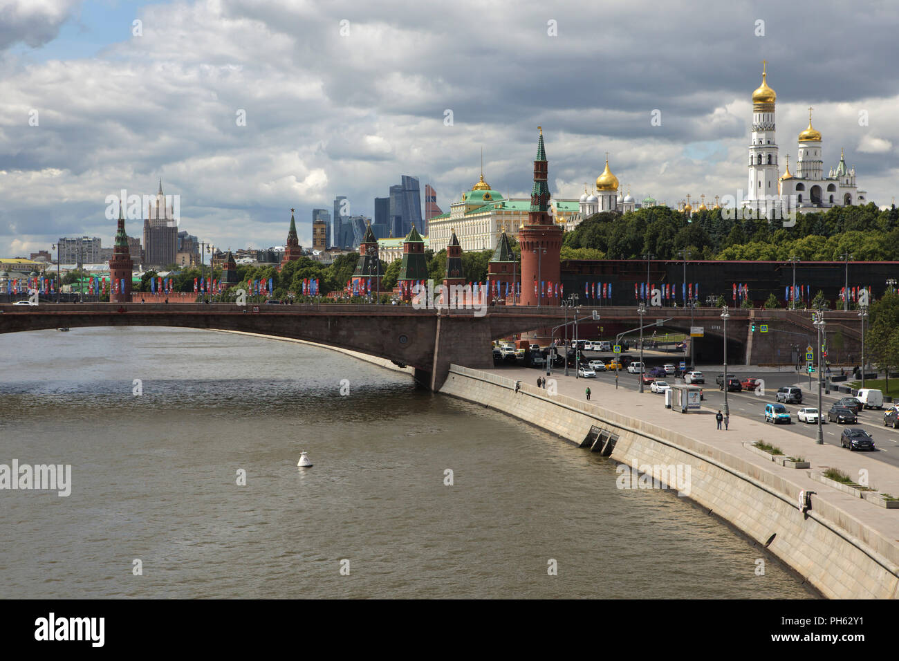 Moscow Kremlin and the Bolshoy Moskvoretsky Bridge over the Moskva River pictured from the Floating Bridge in Zaryadye Park in Moscow, Russia. Skyscrapers of the Moscow International Business Centre, also known as Moscow City, and the main building of the Ministry of Foreign Affairs of Russia, one of the seven Stalinist skyscrapers designed Soviet architects Vladimir Gelfreykh and Adolf Minkus. Stock Photo