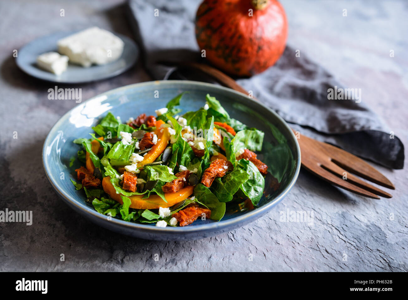Healthy pumpkin salad with sun dried tomato, lettuce and Feta cheese Stock Photo