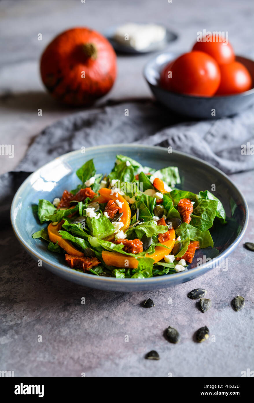 Healthy pumpkin salad with sun dried tomato, lettuce and Feta cheese Stock Photo