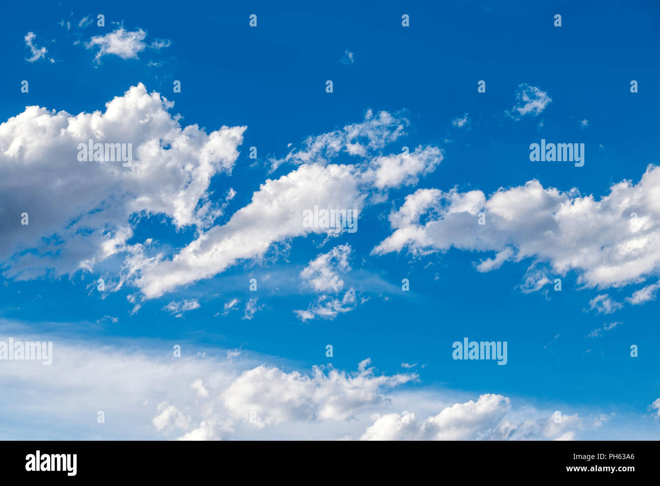 Puffy white cumulus clouds against a clear blue central Colorado sky; USA Stock Photo