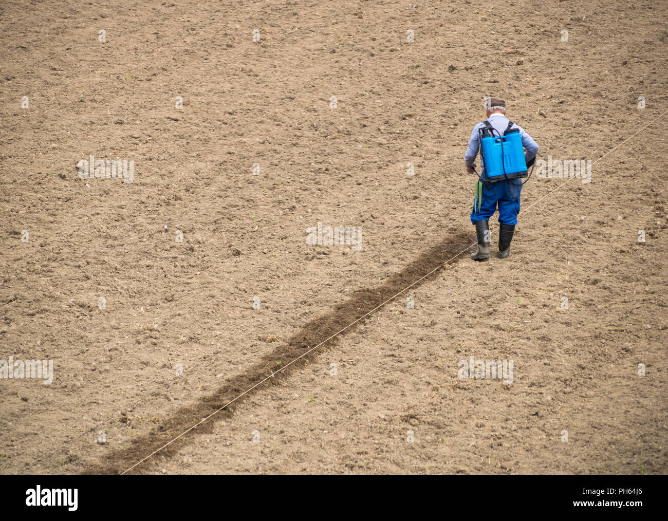 man fumigates the land of the field before cultivating the harvest Stock Photo