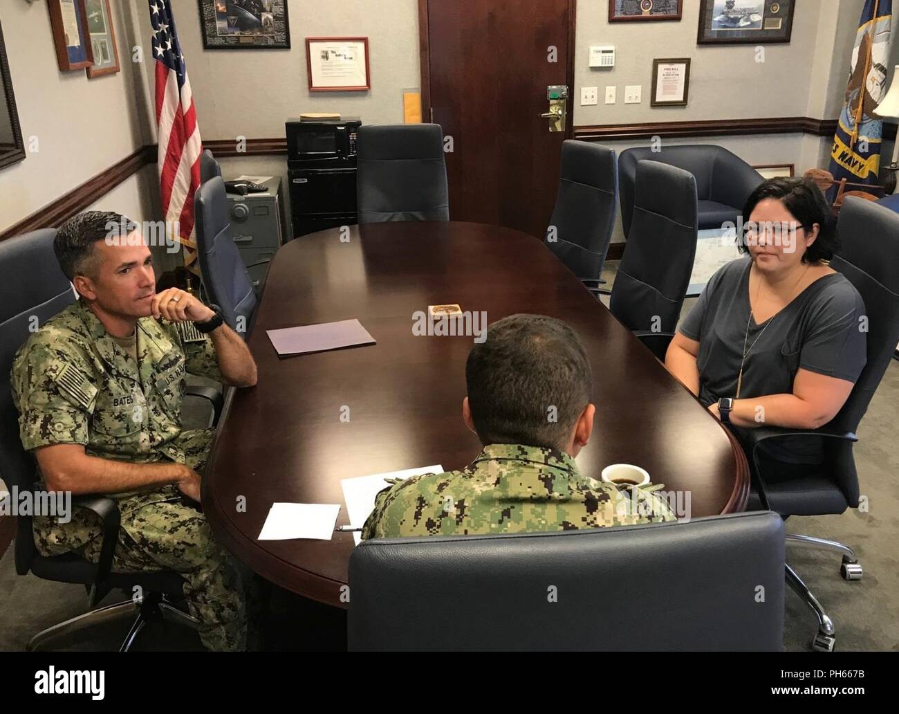 Fla. (June 27, 2018) Heidi Theis, the Center for Information Warfare Training Command's (CIWT) ombudsman, met with Capt. Nick Andrews (center), CIWT's commanding officer, and CIWT's Command Master Chief Mike Bates this morning. The morale, health, welfare, and efficiency of command personnel are the responsibility of the commanding officer. The command ombudsman assists the commanding officer in carrying out this responsibility. Ombudsmen are professionally trained information and referral volunteers who serve as a vital two-way communication link between the command and family members. The pr Stock Photo
