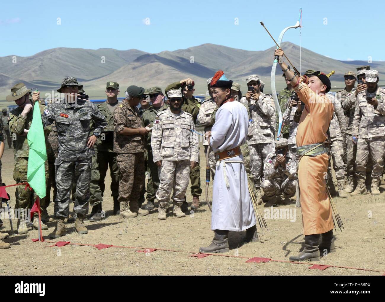 Traditional Mongolian archers shoot at a target during the Nadaam Festival as part of Khaan Quest 2018 at Five Hills Training Area, Mongolia, June 27.  KQ18 is a regularly scheduled, multinational exercise co-sponsored by U.S. Pacific Command and hosted annually by the Mongolian Armed Forces.  This exercise is the latest in a continuing series of exercises designed to promote regional peace and security.  This year's exercise marks the 16th anniversary of this training event. Stock Photo