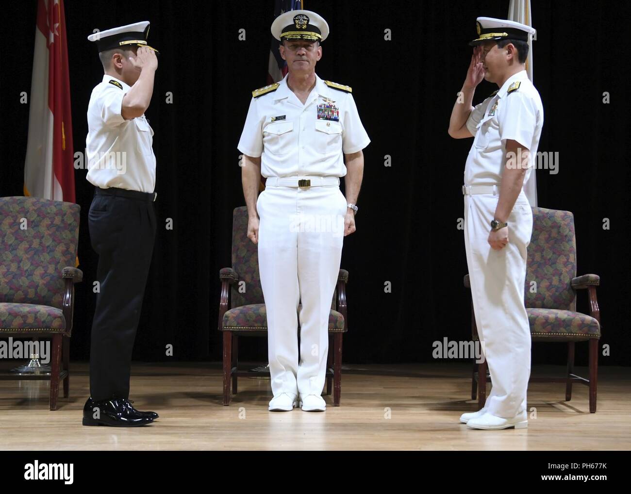 MANAMA, Bahrain (June 28, 2018) Vice Adm. Scott Stearney, middle, commander of U.S. Naval Forces Central Command, U.S. 5th Fleet and Combined Maritime Forces,  presides over a change of command between Republic of Singapore Navy Rear Adm. Saw Shi Tat, incoming commander of Combined Task Force (CTF) 151 left, and Japan Maritime Self-Defense Force Rear Adm. Daisuke Kajimoto, outgoing commander of Combined Task Force (CTF) 151 during the task force's change of command ceremony on Naval Support Activity Bahrain. CTF 151's mission is to disrupt piracy at sea and to engage with regional and other pa Stock Photo