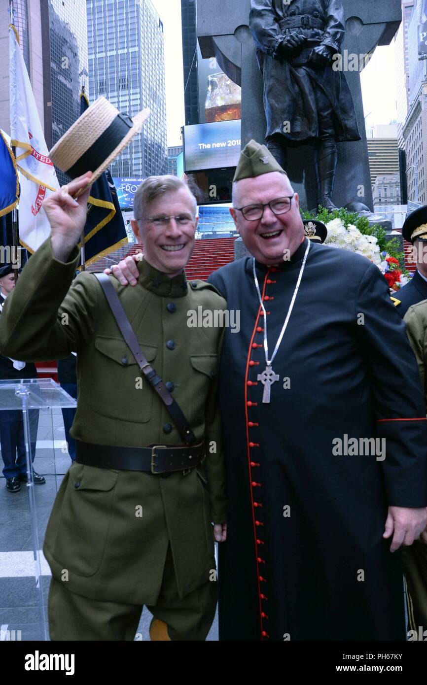 Archbishop of New York Cardinal Timothy Dolan, right, shares headgear with retired Army Col. John Boyd in reenactor Doughboy uniform following the commemoration at the statue of New York Army National Guard Chaplain Father Francis P. Duffy at Times Square June 27, 2018. The two honored Duffy’s service in WWI as part of the 69th Infantry Regiment for the anniversary of his death on June 26, 1932. U.S. Army National Guard Stock Photo