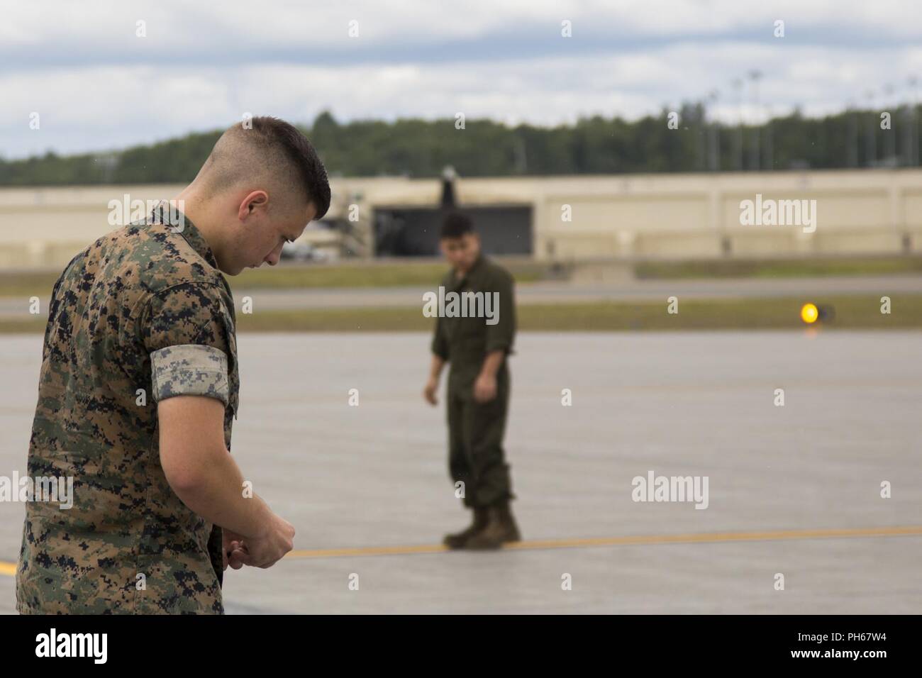 Lance Cpl. Raymond Boule, an airframe maintenance technician assigned to Marine Attack Squadron (VMA) 214, conducts a Foreign Object Debris (FOD) walk in preparation for the arrival of their AV-8B Harriers at Joint Base Elmendorf-Richardson, Alaska, June 27, 2018. VMA-214 will participate in the 2018 Arctic Thunder Air Show with a flyby, hover demonstration, and a static display. Stock Photo
