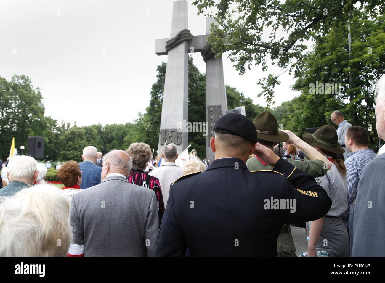Sergeant Maj. Sael Garcia, 1st Infantry Division Mission Command Element sergeant major, salutes during the Polish national anthem at the start of a ceremony in commemoration of the 1956 Poznań Uprising June 28, 2018, at the Crosses monument in Poznań, Poland, which stands in honor of the Polish citizens who stood up against communist rule 62 years ago. The massive protests in 1956 were the first of many in which hundreds of Polish people sacrificed their lives for the independence of Poland. Hundreds of Polish citizens, including uprising participants, attended the ceremony. Also in attendanc Stock Photo
