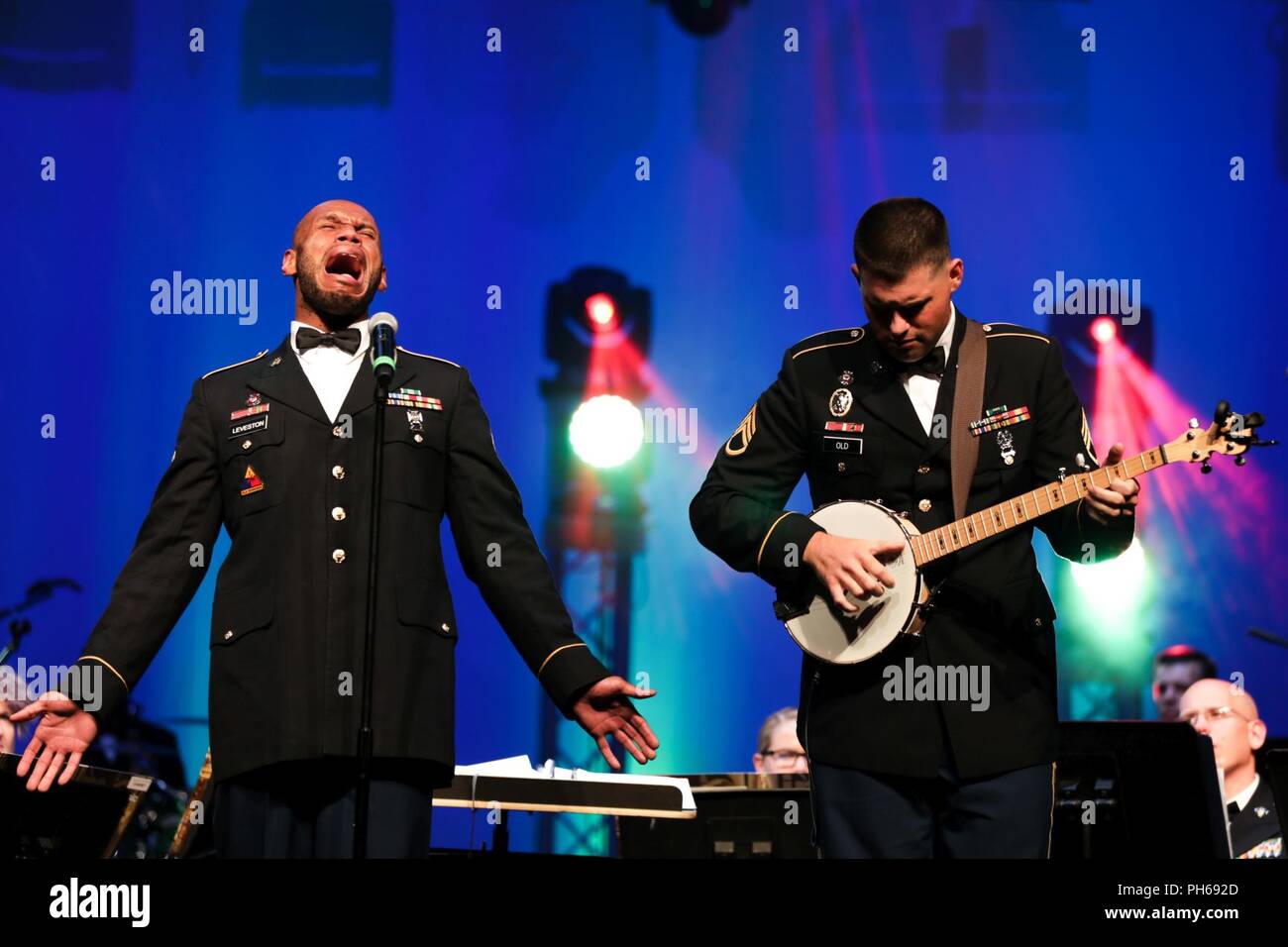 U.S. Army Spc. Joseph Leveston vocalist and Staff Sgt. James Old on the banjo soldiers with the 389th U.S. Army Materiel Command Band perform banjo music of the Tennessee Valley at Bob Jones High School, Alabama, June 26, 2018. The AMC Band performed to a packed audience during their final concert before inactivation. Stock Photo
