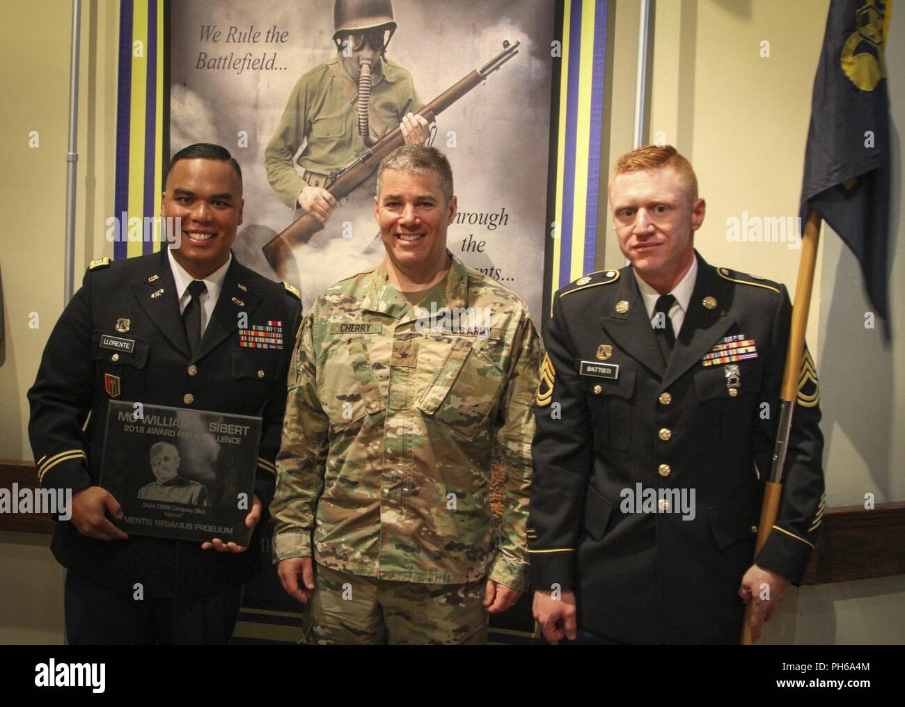 Army Reserve Capt. Lorenzo Llorente II (left), company commander, 342nd Chemical Company, 472nd Chemical Battalion, 209th Regional Support Group, 76th Operational Response Command,  Brig. Gen. Doug Cherry, (center) deputy commanding general, 76th ORC, and Sgt. 1st Class John Baptisti (right), company first sergeant, 342nd Chem. Co., 472nd Chem. Bn., pose for  aphoto together after the 342nd Chemical Company was presented the prestigious Maj. Gen. William L. Sibert award at the Baker Theater on Fort Leonard Wood, Missouri during the 100th anniversary of the Chemical Corps June 28.  This is the  Stock Photo