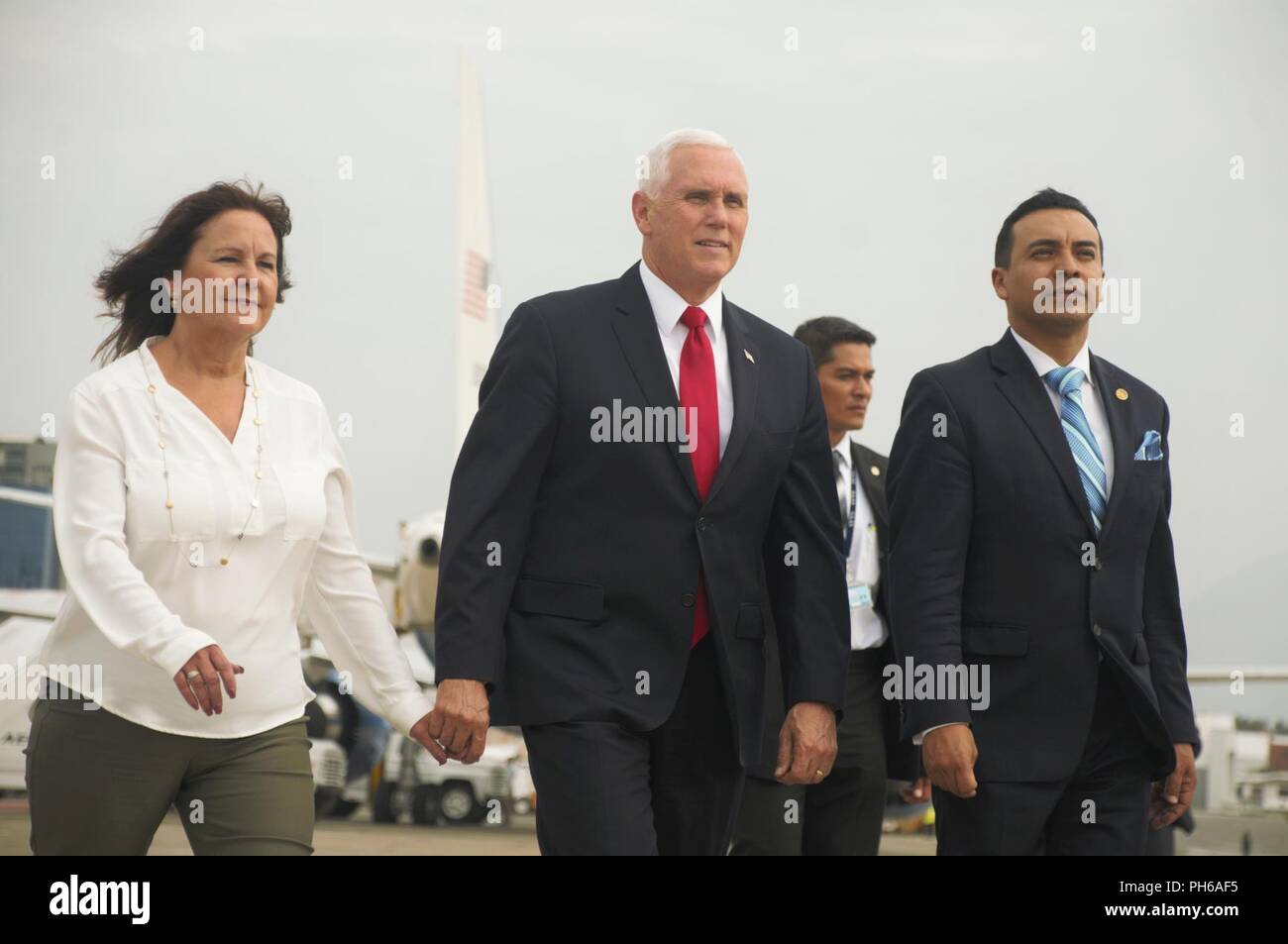 U.S. Vice President Mike Pence, center escorts his wife, Karen Pence, across the flight line at La Aurora International Airport in Guatemala City, Guatemala, to meet Guatemala’s first lady, Patricia Morales, June 28, 2018. Karen Pence flew with Morales on a CH-53E Super Stallion helicopter with Special Purpose Marine Air-Ground Task Force - Southern Command to visit La Escuintla, an area damaged by volcanic eruptions by Fuego Volcano. Pence and her staff delivered care packages to families and assessed the total damage caused by the volcano that has affected the lives of millions in the area.  Stock Photo