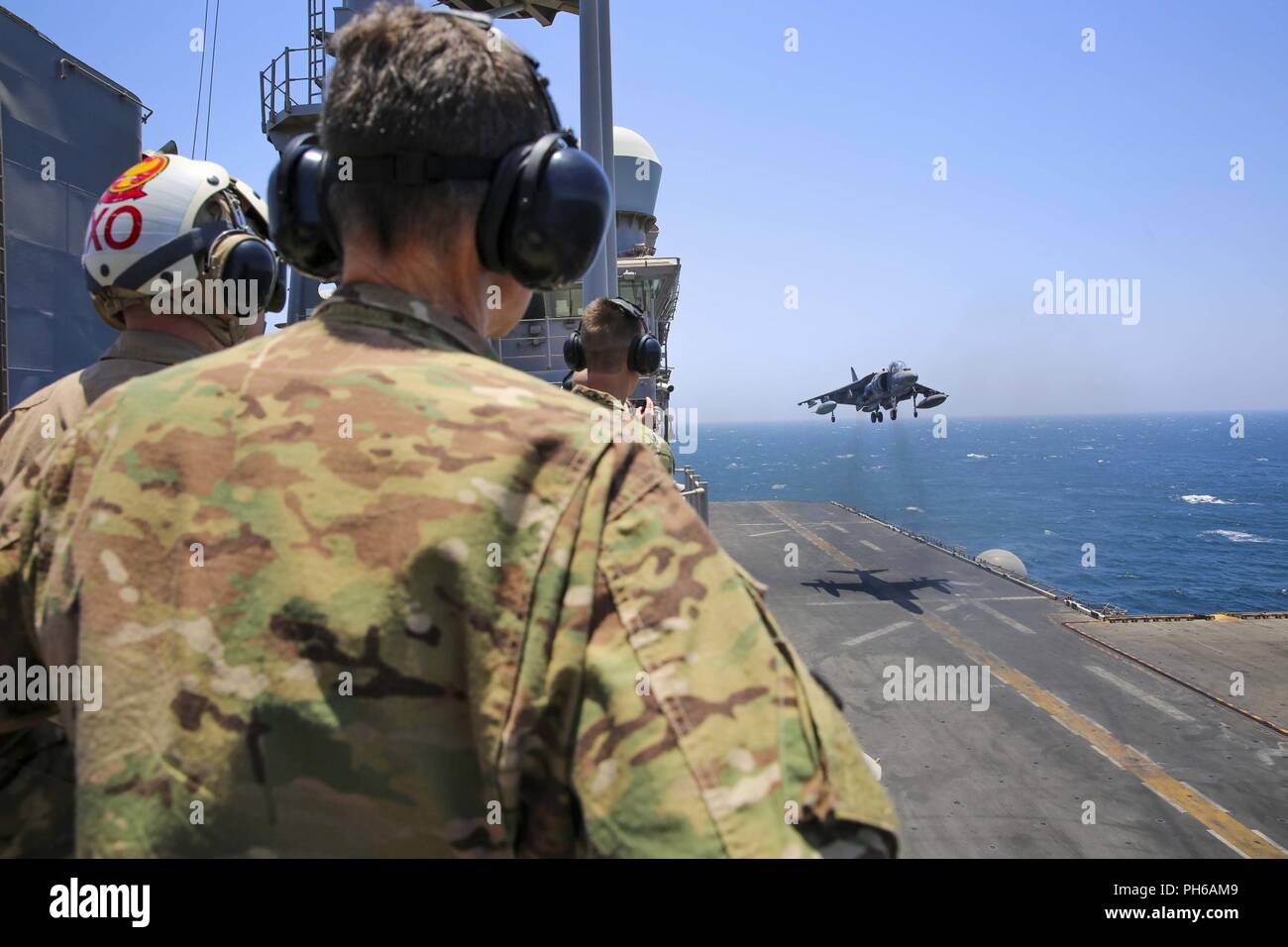 ARABIAN GULF (June 22, 2018) U.S. Army Gen. Joseph Votel, commander, U.S. Central Command, watches as an AV-8B Harrier lands aboard the Wasp-class amphibious assault ship USS Iwo Jima (LHD 7), June 22, 2018. Votel, Vice Adm. Scott Stearney, commander, U.S. Naval Forces Central Command, and other distinguished visitors took a tour of Iwo Jima and spoke with crew members and Marines with the 26th Marine Expeditionary Unit, who are currently deployed to the U.S. 5th Fleet of operations in support of maritime security operations to reassure allies and partners and preserve the freedom of navigatio Stock Photo