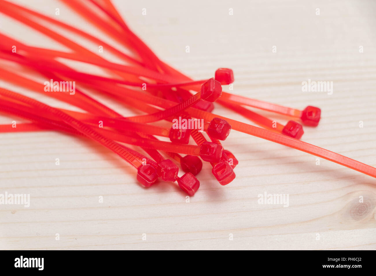 Multiple many red zip ties tie isolated on wood Stock Photo Alamy