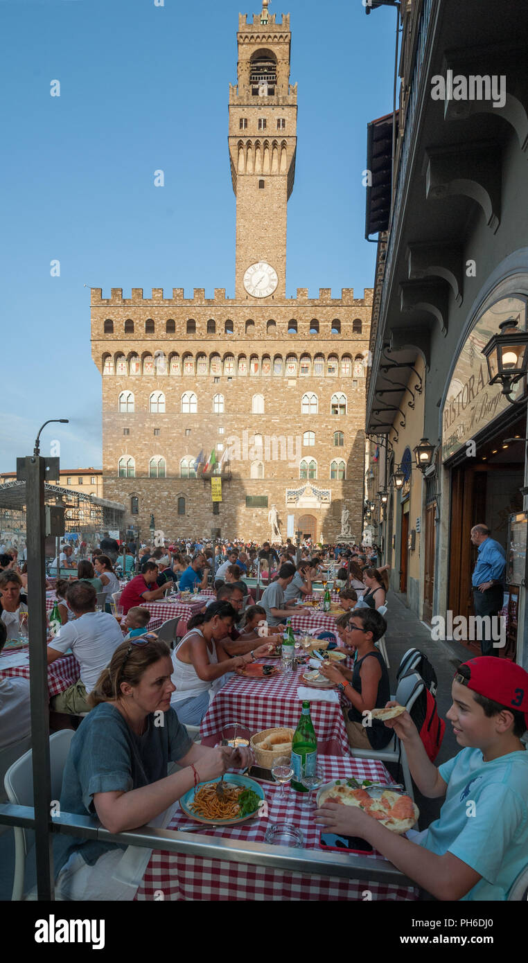 Florence, Italy - 2018, July 14: Tourists eating pizza and spaghetti at the restaurant in Piazza della Signoria, Florence. Stock Photo