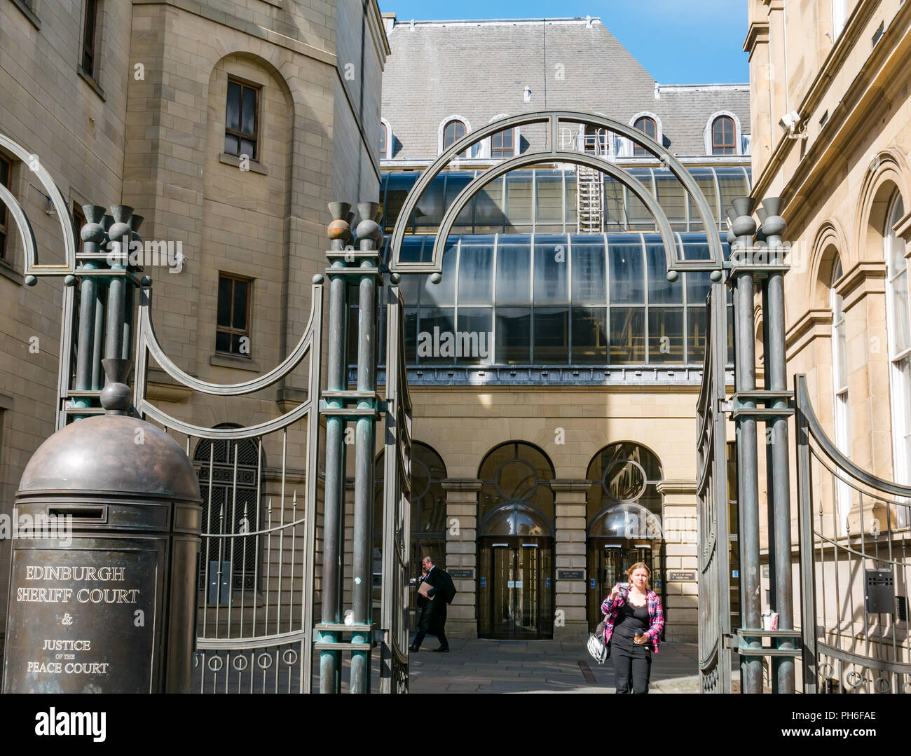 Front of Edinburgh Sheriff Court, Chambers Street, Edinburgh, Scotland, UK with name sign at entrance gate and lawyer in gown outside Stock Photo