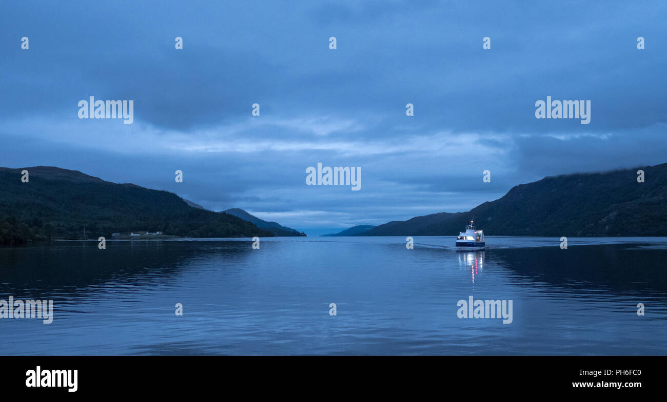Loch Ness, central Highlands of Scotland. Boat on the water at twilight. Photographed at Fort