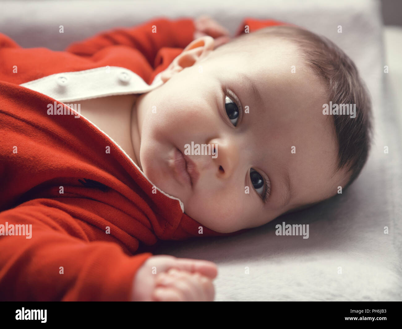 photo Cute Boy Brown Hair Brown Eyes https www alamy com closeup portrait of cute adorable caucasian baby boy girl with black brown eyes in red hoodie shirt on changing table looking directly in camera natu image217119703 html