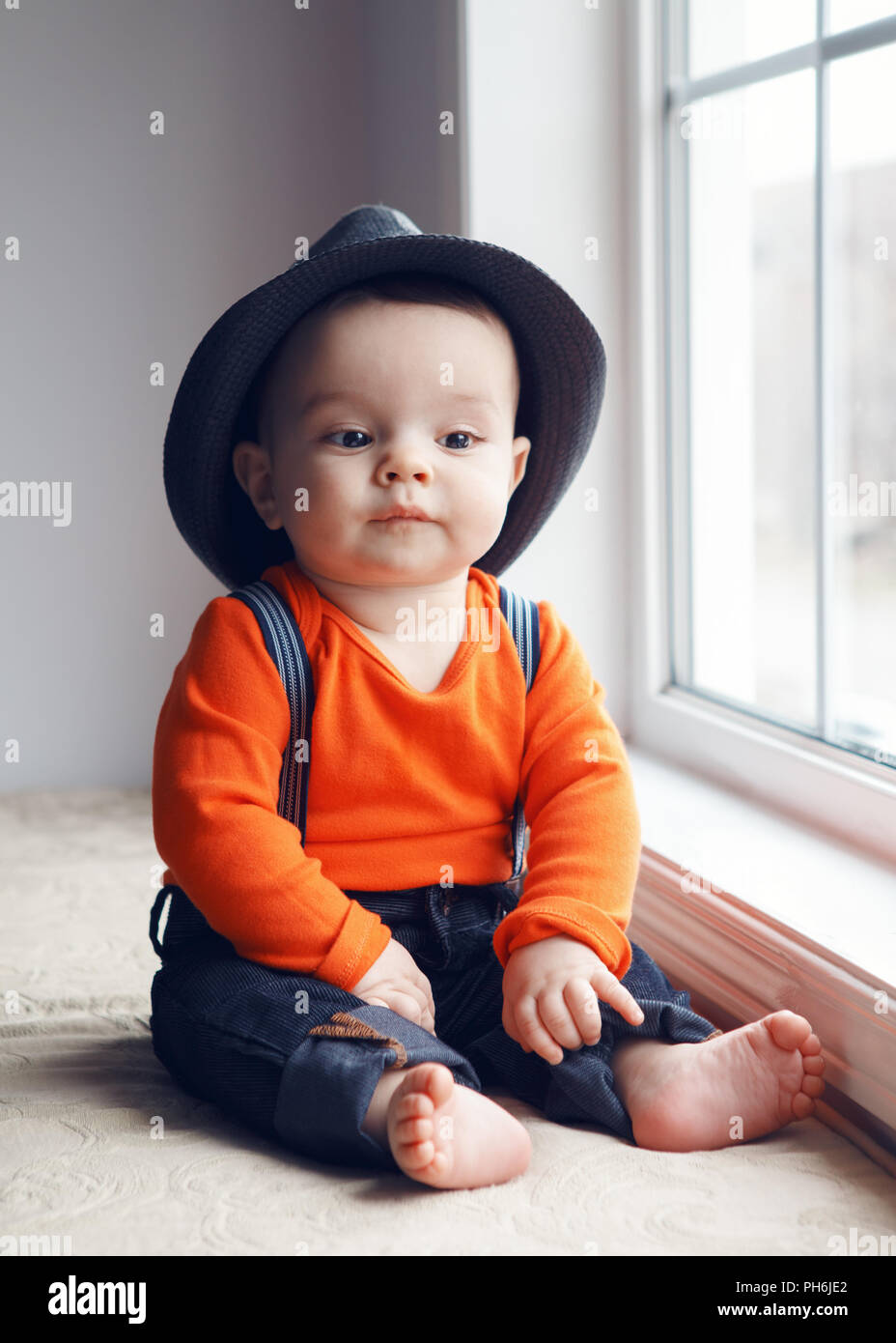 Portrait of cute adorable stylish Caucasian baby boy with black ...