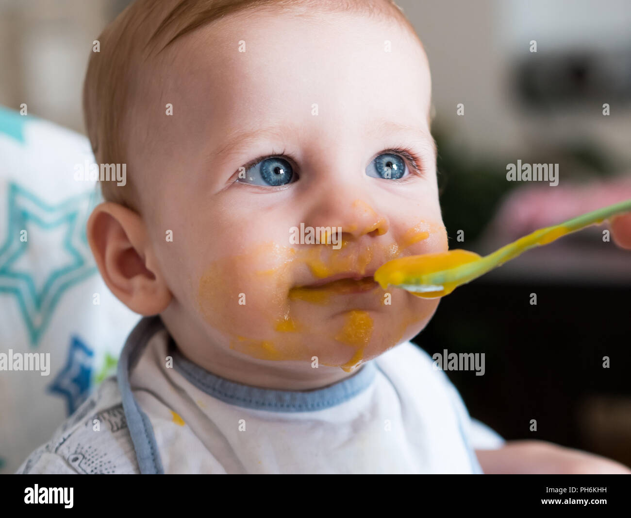 Mother feeding cute baby boy with blue eyes close up Stock Photo