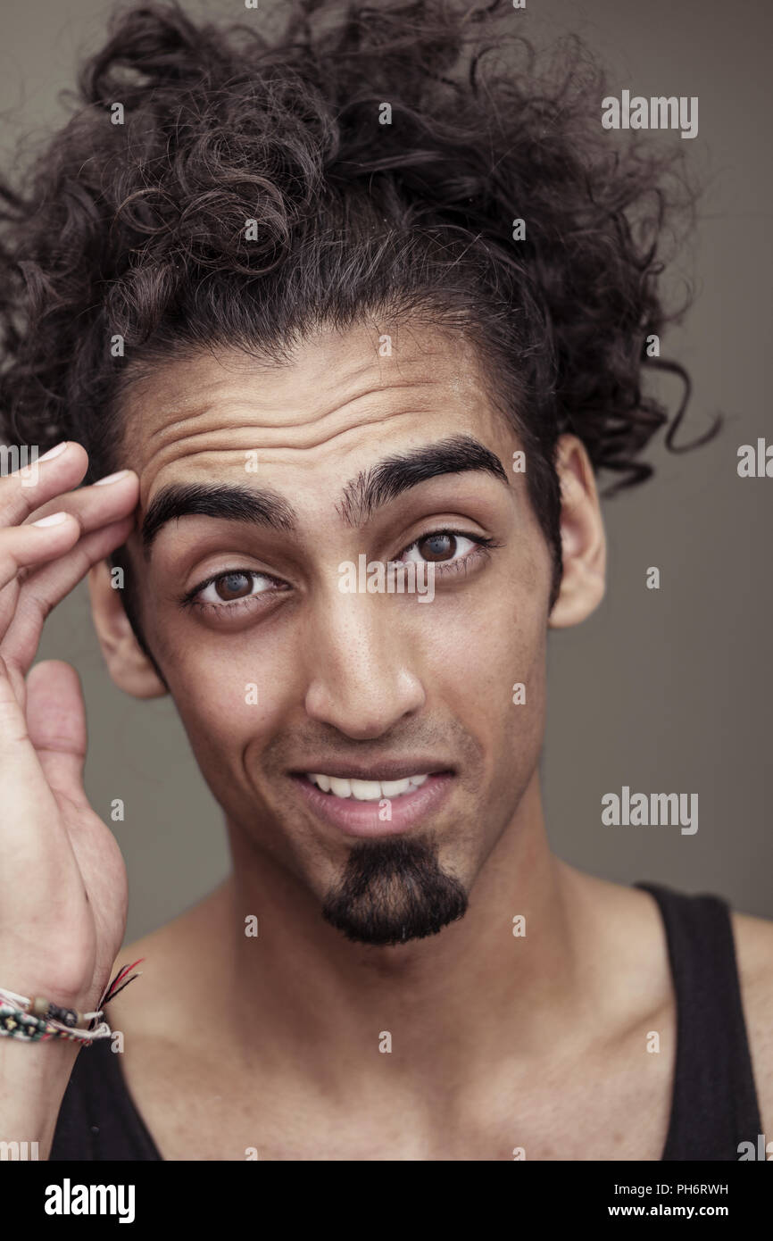 Curly-Haired Young Man Smiling at the Camera Stock Photo