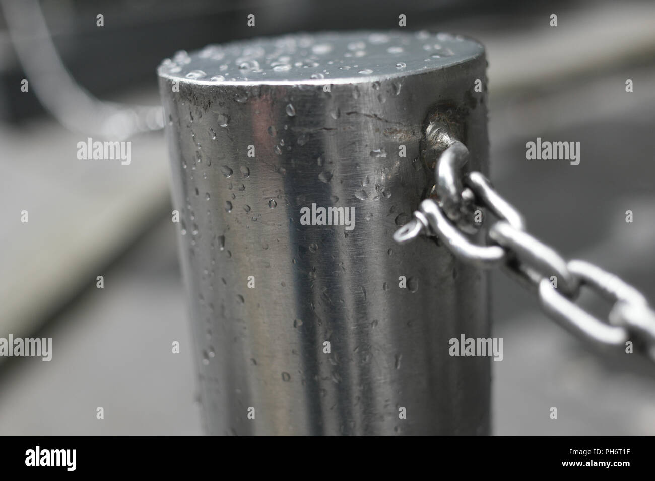 Metal bollard with chain link fence Stock Photo - Alamy