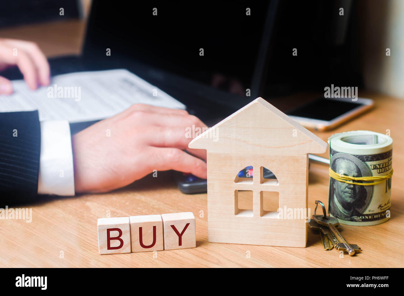 Realtor with a house on your desktop. Buying and selling real estate. Acquisition of property