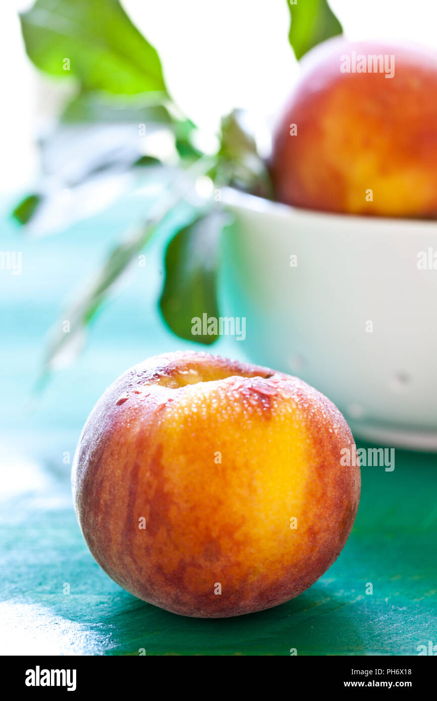 Fresh organic peaches on green background Stock Photo